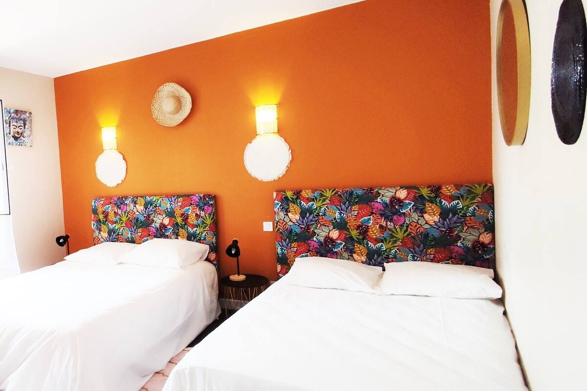 Une chambre d’hôtel avec deux lits, un bureau, une chaise et un téléviseur.