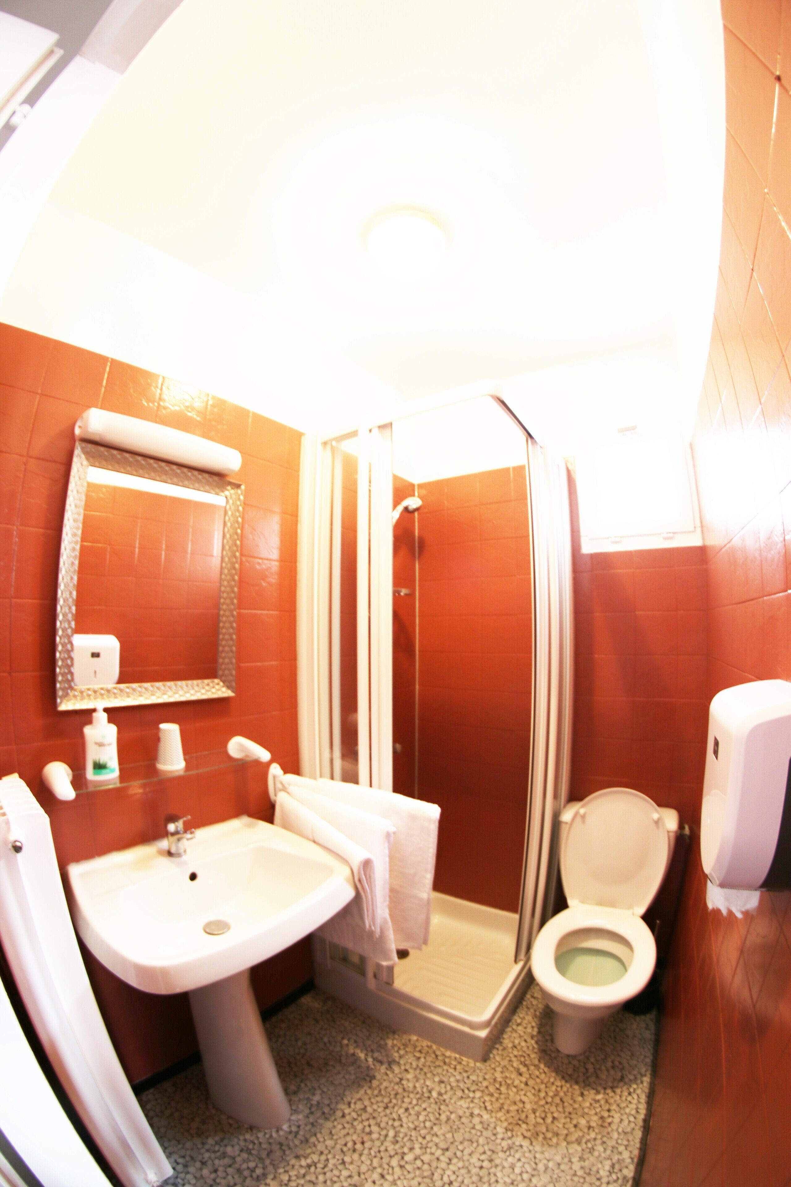 A bathroom with a sink, toilet, and shower.