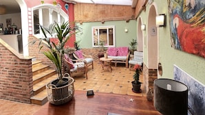 Un amplio patio con mesa, sillas y zona de comedor de madera.
