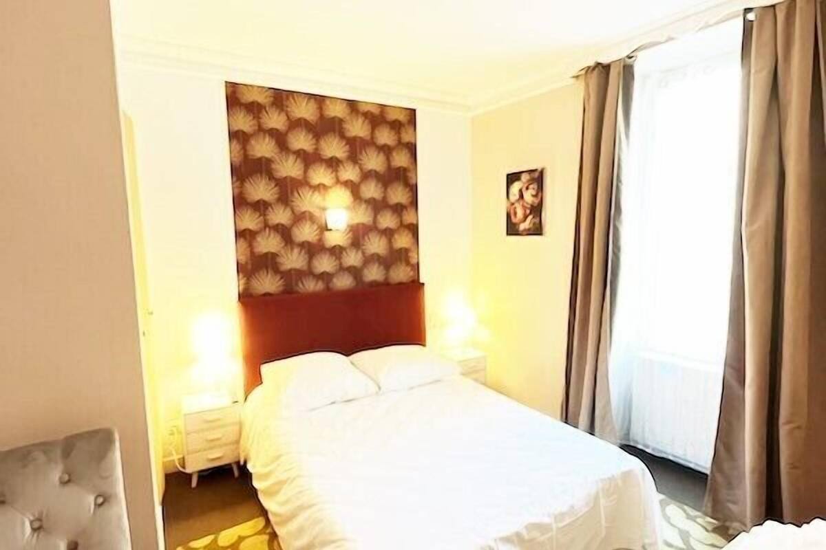 Une chambre d’hôtel comprenant un lit, des tables de chevet, une chaise et un bureau.