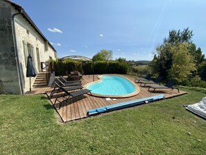 A backyard with a swimming pool, wooden deck, and outdoor furniture. - Le Buis - Old barn with private pool (Chalais)