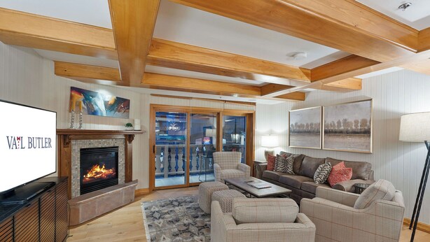 A spacious living room with a fireplace, a large television, and a comfortable seating area.