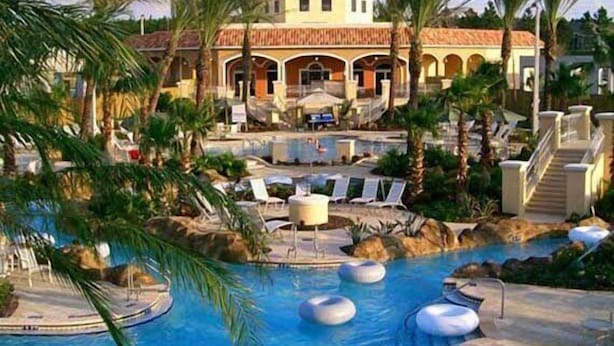 A resort with a swimming pool, palm trees, and a building with a dome roof. - RP144BD - Disney Regal Palms Townhome near Disney - Come on by! (Davenport)