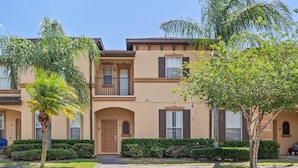 A residential building with a brick pathway, a small entrance, and a balcony. - RP144BD - Disney Regal Palms Townhome near Disney - Come on by! (Davenport)
