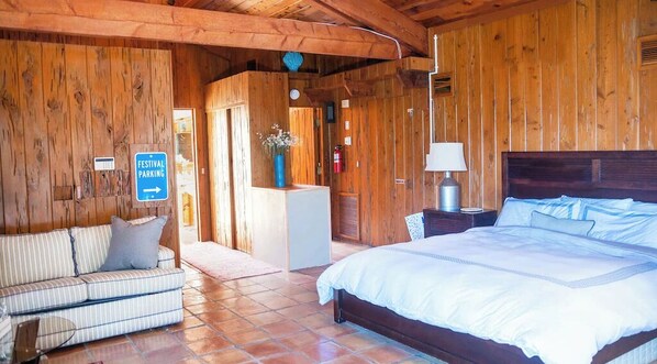 Relax in this inviting room with a comfortable bed, bedside table, and cushioned bench.