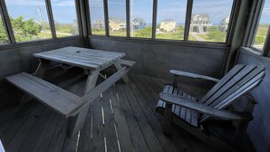 A wooden deck with a picnic table and two Adirondack chairs, overlooking a residential area with houses and a clear sky. - Swinkels is a spacious 3 bedroom, 1.5 bath home that is a true jewel! (FRISCO)