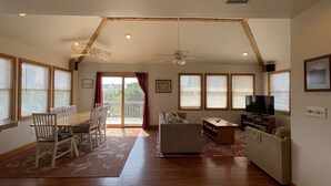 A living room with a dining area, a sofa, a TV, and a balcony with a view. - Swinkels is a spacious 3 bedroom, 1.5 bath home that is a true jewel! (FRISCO)