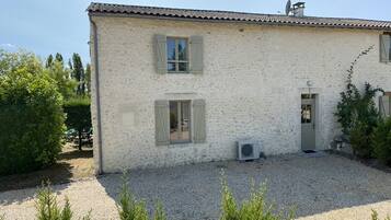 Un bâtiment à deux étages avec une allée en gravier et un petit jardin.