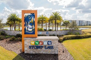 A sign with 'STORY LAKE' and icons indicating amenities like a pool, restaurant, and fitness center.