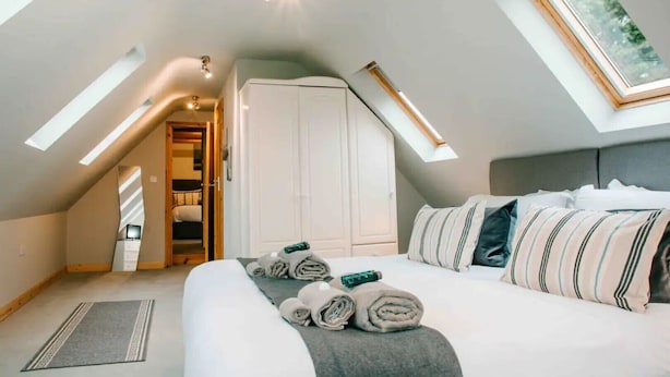 Ein Schlafzimmer mit einem großen Bett, einem Kleiderschrank und einem Oberlicht.