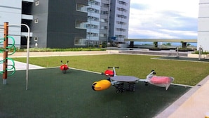 Ein Spielplatz mit einer Kletterkonstruktion, einer Wippe und einem Ball.