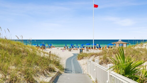 A beach with a pathway leading to the sea, blue umbrellas, and beach chairs. - Cozy Family Beach Home, Golf Cart and near  StAndrews PCB (Panama City)