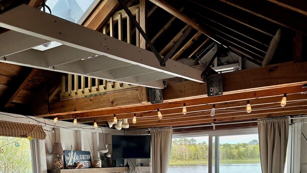 Een gezellige woonkamer met een open haard, comfortabele zitmogelijkheden en uitzicht op een meer.