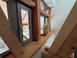 A wooden staircase with a window leading to a balcony.