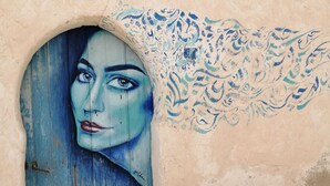 Un edificio rústico con una puerta desgastada y un mural decorativo en la pared.