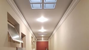 A hallway with a black tiled floor, white walls, and a red accent wall at the end. - Hotel Namorata Expo Inn (São Paulo)