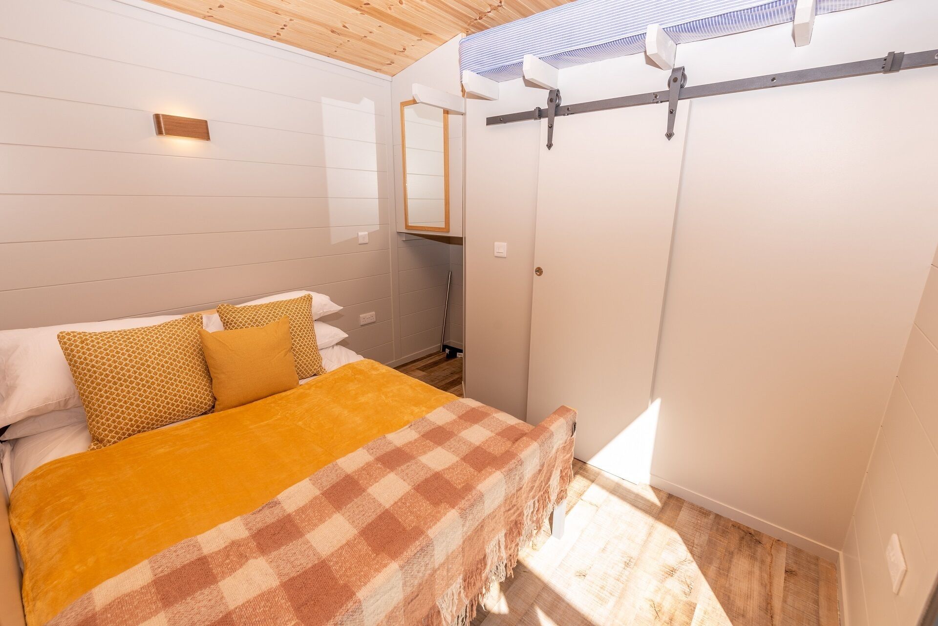 Une chambre à coucher avec un lit, une couverture à carreaux et une armoire.