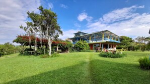 A large house with a covered porch and a well-maintained lawn. - Brugmansia Country Hotel (Montenegro)