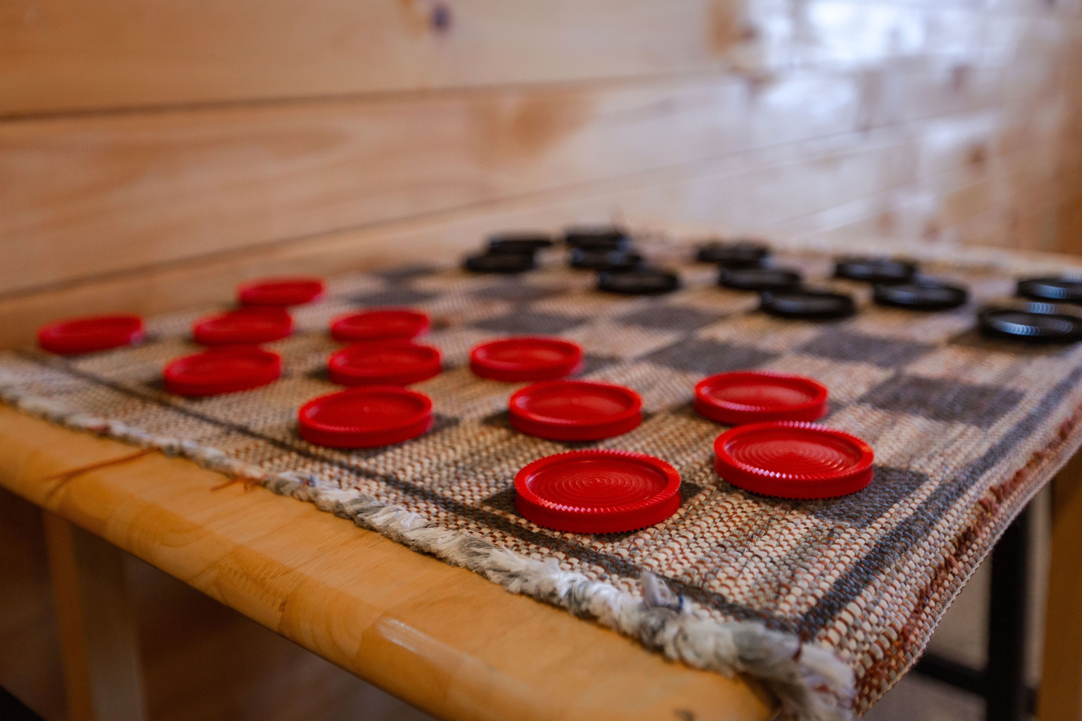 A checkered table with red and black tokens.