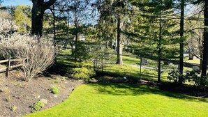 A grassy area with trees and a wooden fence. - Perfect location in the heart of downtown Lenox (Lenox)