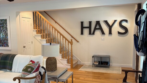 A living room with a staircase, a sofa, a wooden chair, a table, and a coat rack. - Perfect location in the heart of downtown Lenox (Lenox)