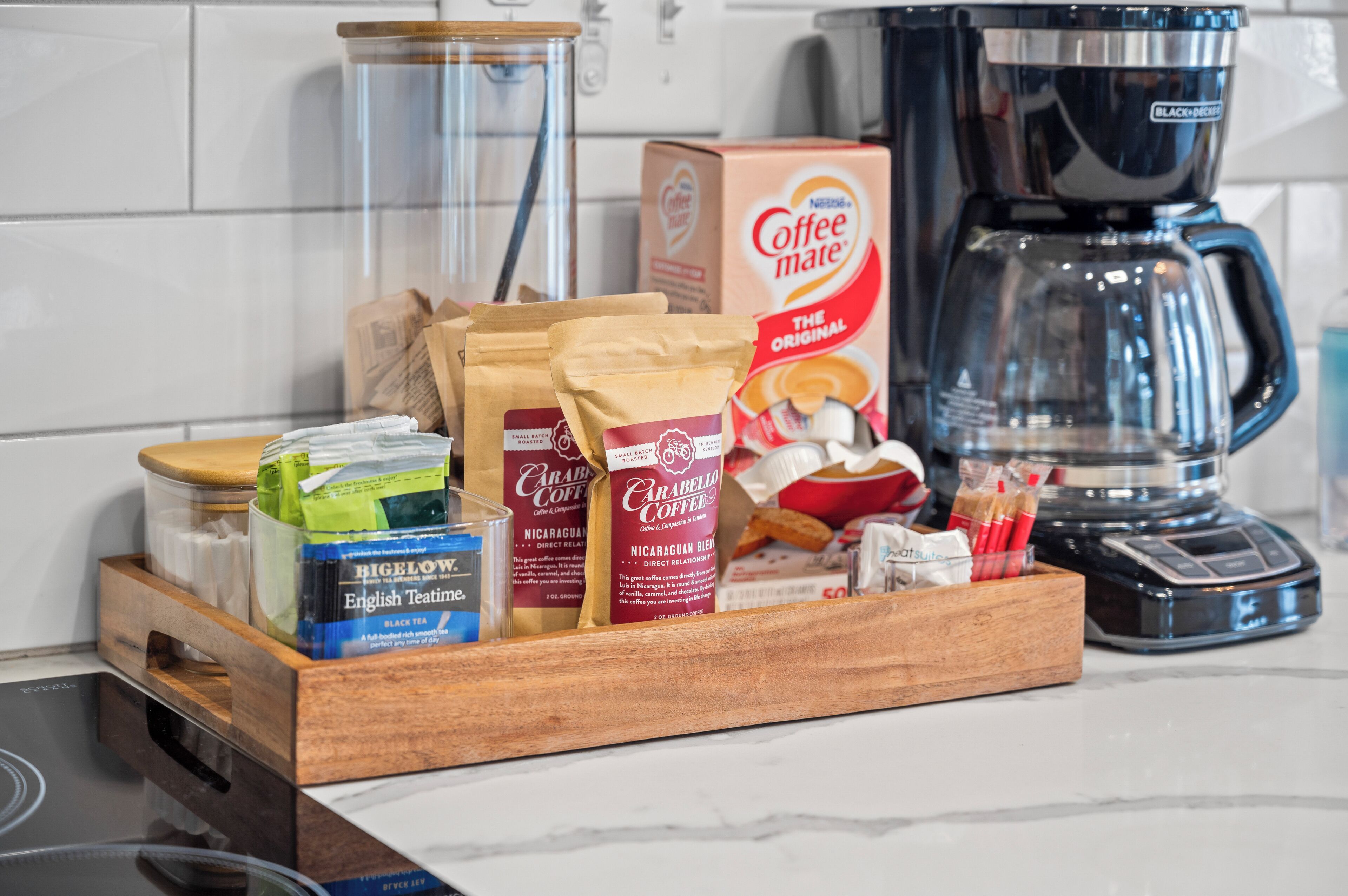 A kitchen counter with a coffee maker, coffee pods, and coffee bags.