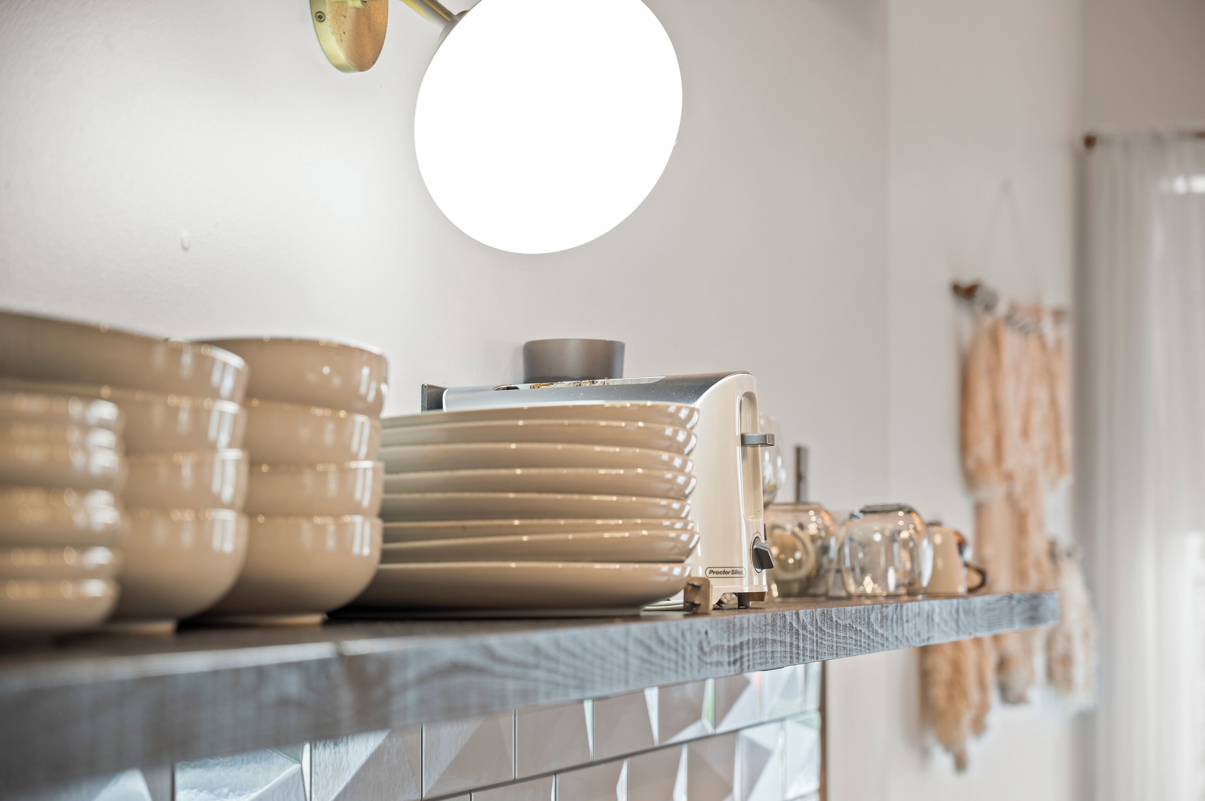A kitchen counter with stacked plates and a coffee maker.