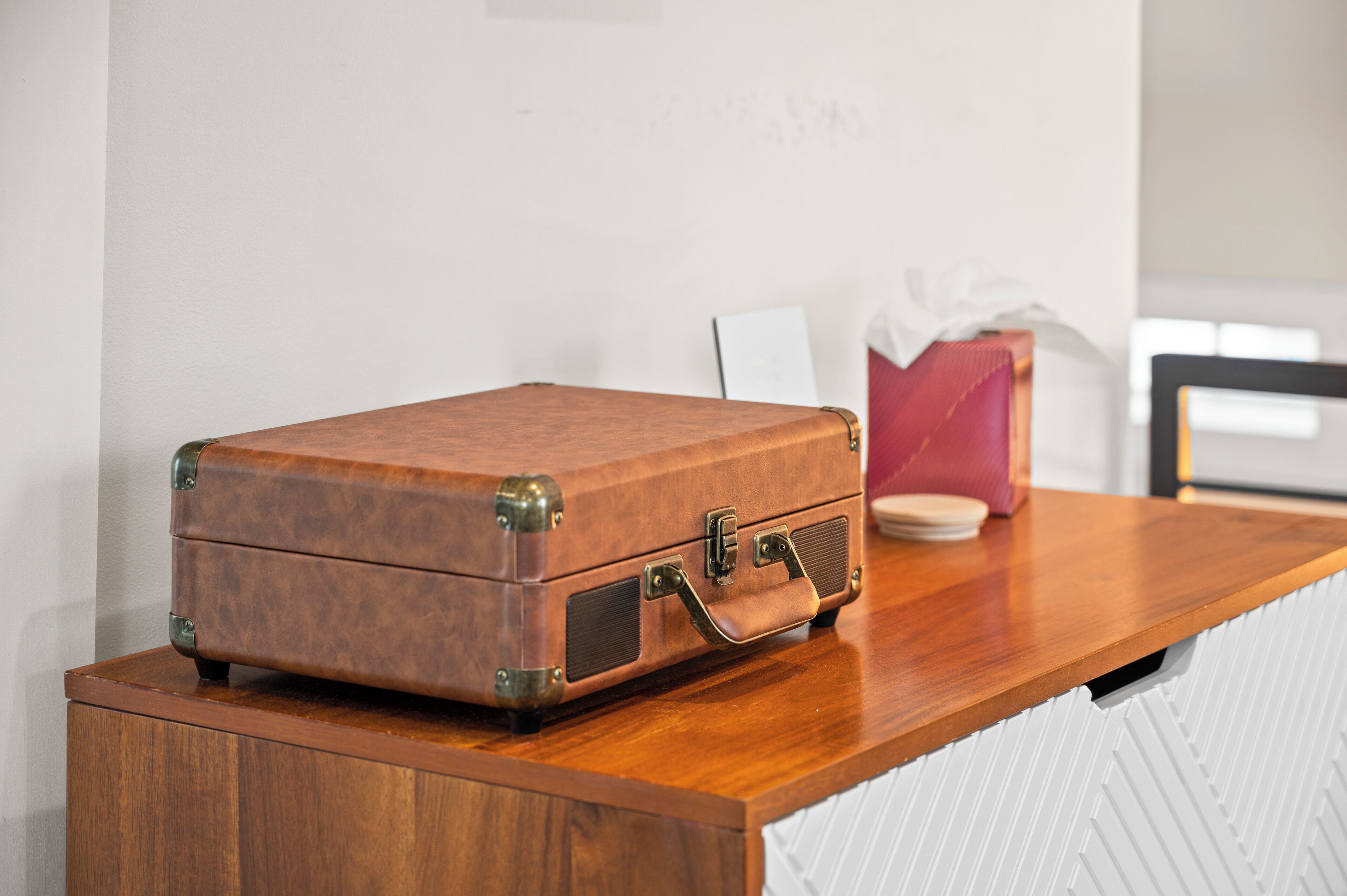 Une table en bois sur laquelle est posée une vieille valise marron.