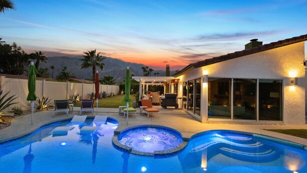 A backyard with a swimming pool, patio furniture, and a covered seating area. - Lush & Tranquil 3BR Palm Springs Oasis Pool & Spa (Palm Springs)