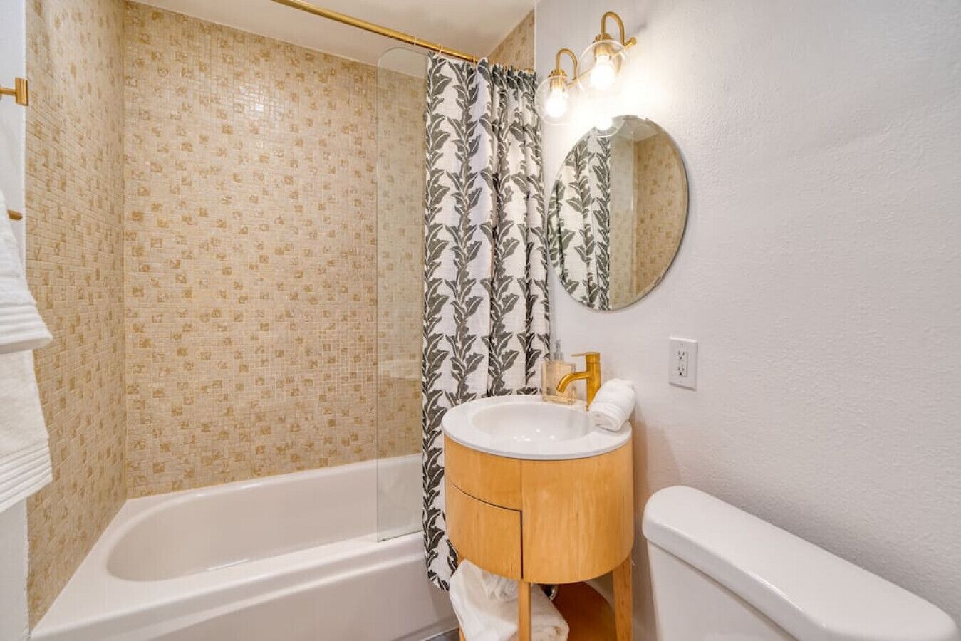Une salle de bain avec une baignoire, un lavabo avec un miroir et un rideau de douche.