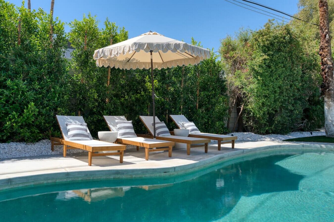 A poolside area with lounge chairs and a canopy.