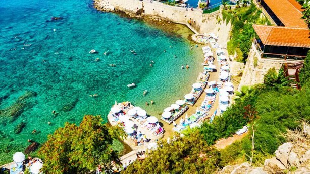 A coastal marina with boats, a pier, and beach umbrellas. - Villa Citronella Boutique Hotel (Antalya)