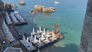 A coastal resort with a pool, sun loungers, and a view of the sea and mountains. - Villa Citronella Boutique Hotel (Antalya)