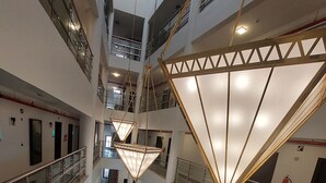 A spacious atrium with multiple levels, modern furniture, and a unique geometric light fixture. - Karims'Hotel (Al Majmaah)