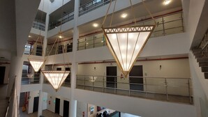 A multi-level atrium with a modern design, featuring a central open space with seating and a reception desk. - Karims'Hotel (Al Majmaah)