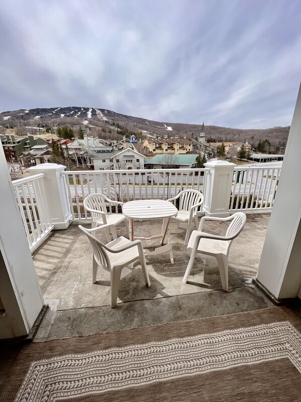 A balcony with a view of a town and mountains.