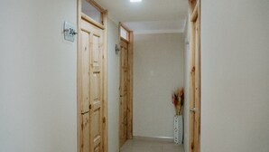 Un pasillo con puertas de madera, un cartel que indica la habitación 304 y un jarrón con plantas secas.