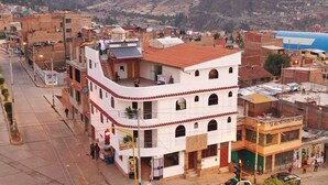 Un edificio de varios pisos con techo plano y un balcón en el segundo nivel.