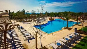 Una zona de piscina amb gandules i una pèrgola.