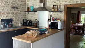Een keuken met een tegels, houten balken en een stenen muur.