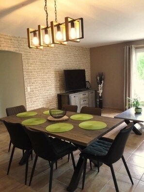 A dining area with a wooden table, black chairs, and green placemats.