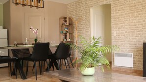 Un comedor con una mesa de madera, sillas negras y una planta en maceta.