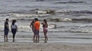 Un barco en el agua, con gente en la playa.
