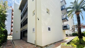 A multi-story residential building with a brick pathway leading to the entrance. - ANAFI - Studio located just 200m from the beach (SALOU)