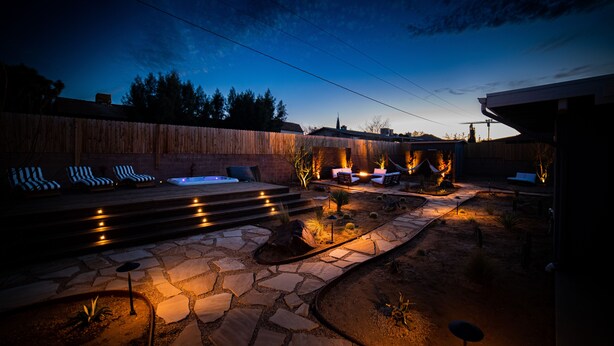 A backyard with a hot tub, lounge chairs, and a stone pathway. - Lucky Moon Retreat | JTree Oasis w/Hot Tub & Pool (Yucca Valley)