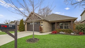 A residential house with a mailbox, a well-maintained lawn, and a brick exterior.