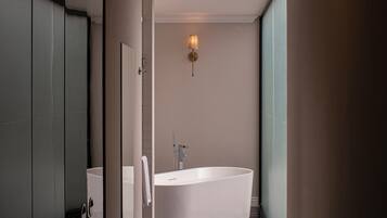 Un baño moderno con una bañera independiente, inodoro y lavamanos.