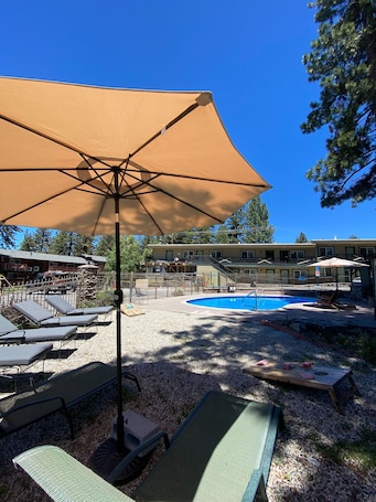 Una piscina al aire libre de temporada, sillones reclinables de piscina