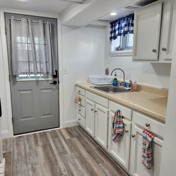 Compact kitchen with a sink, window, and cabinetry.
