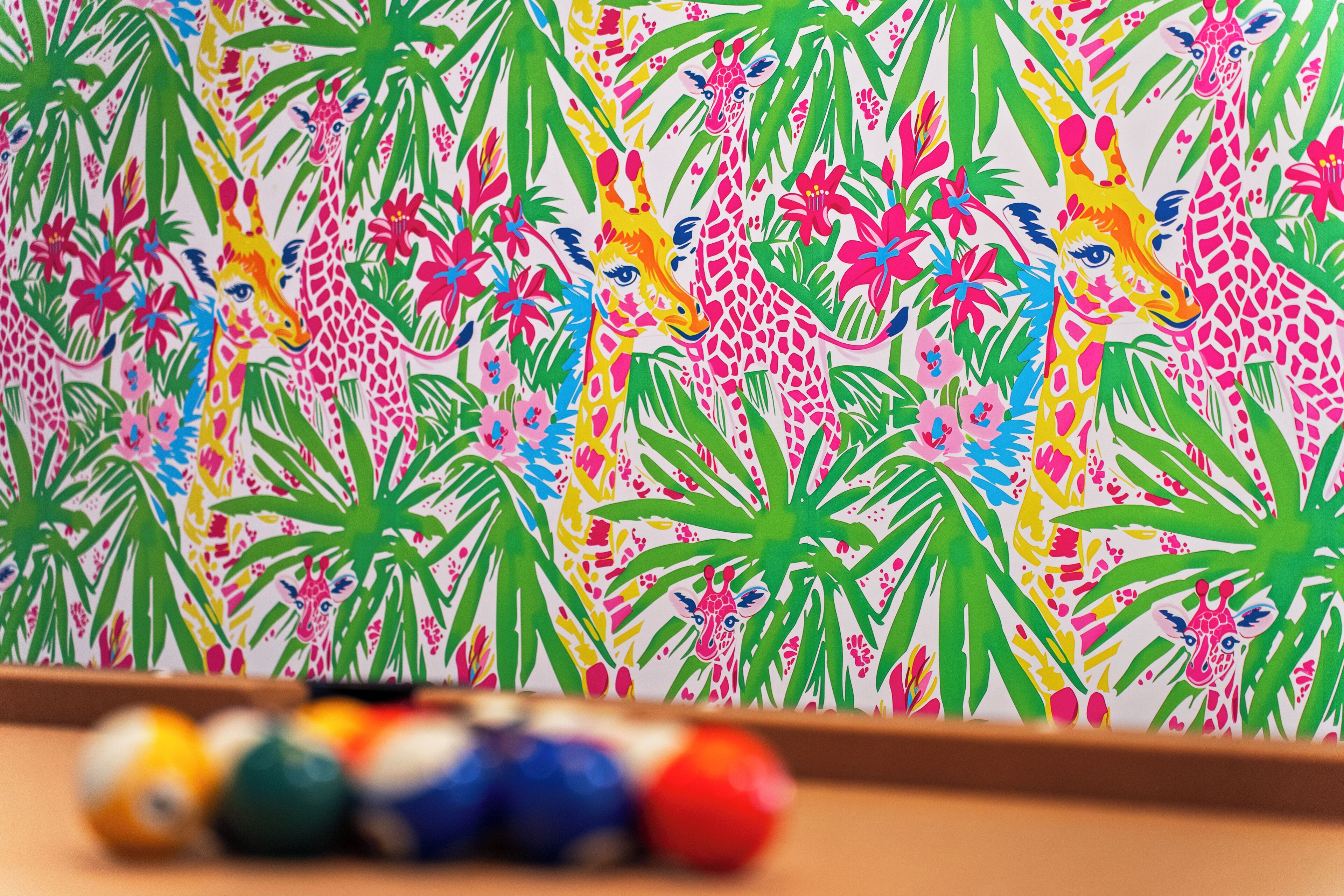 Un mural vibrante con jirafas y follaje tropical.